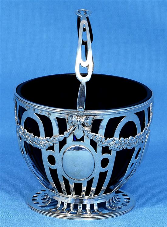 An Edwardian pierced silver sugar basket and blue glass liner, Height to handle 6”/155mm Dia 104mm Weight Silver only: 5.1oz/145grms